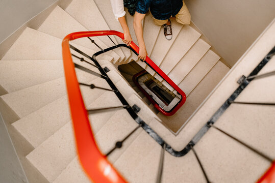 unrecognizable couple quickly descends the stairs