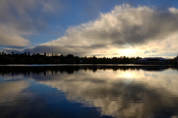 Fototapeta na wymiar Dow's Lake in Ottawa at sunset with large triangle cloud reflection in flat surface