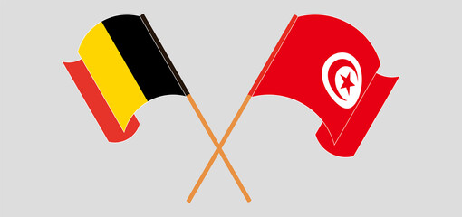 Crossed and waving flags of Belgium and Tunisia