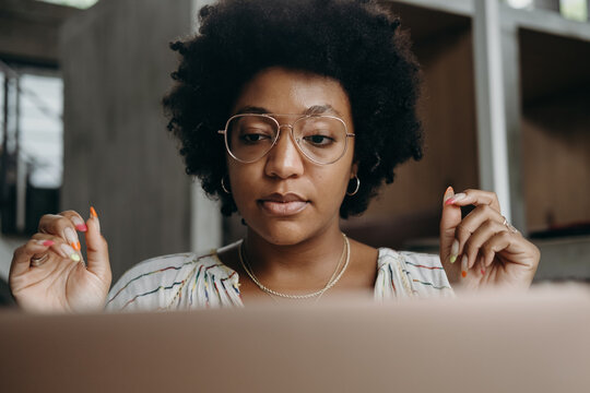 Black freelancer reading data from laptop