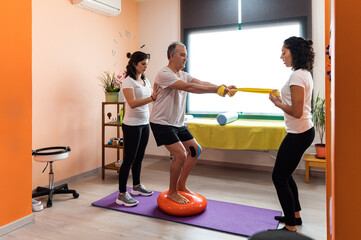 Senior man doing physiotherapy exercise with therapists