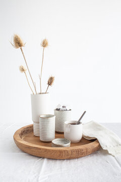 Tea service on wooden tray with dry flowers