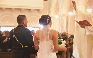 Hispanic bride and groom in wedding ceremony
