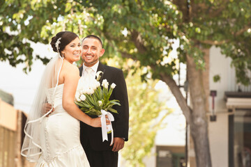 Smiling Hispanic bride and groom