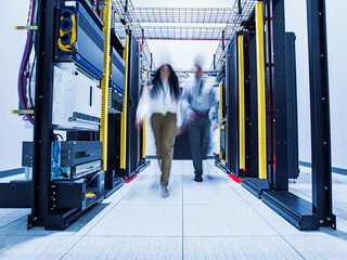 Blurred view of technicians walking in server room