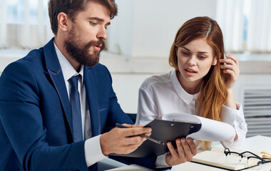 Work colleagues are sitting at the table in front of a laptop technology communication