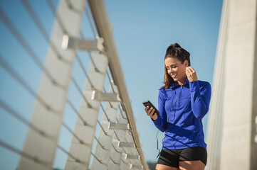 Caucasian woman using cell phone on urban bridge