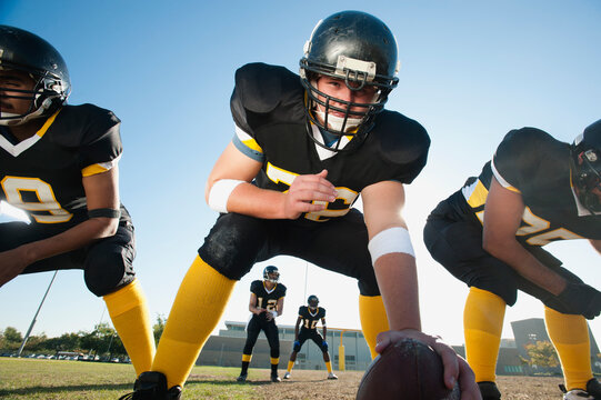 Football players crouching on football field