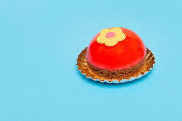Delicious looking small round red cake on a blue background