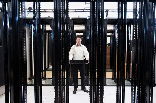 Asian businessman standing in empty server room
