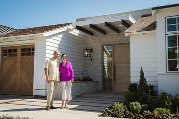 Older couple posing near driveway of house