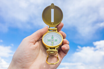 compass in hand against blue sky © Andrey Malkov