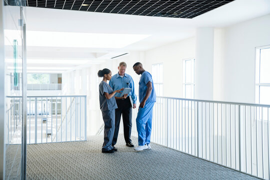 Doctor and nurses discussing digital tablet