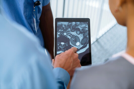 Close up of doctor and nurses viewing image on digital tablet