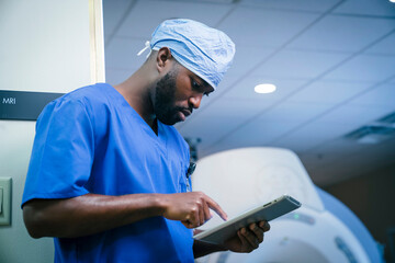 Serious black nurse using digital tablet
