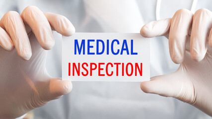 Doctor holding a card with text MEDICAL INSPECTION