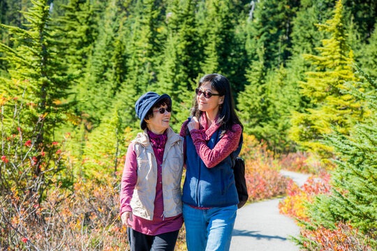 Older Japanese Mother And Daughter Walking On Nature Path