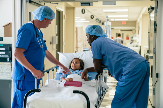 Nurses talking to girl in hospital gurney