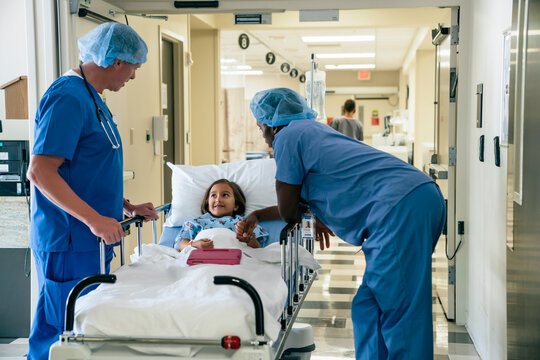 Nurses talking to girl in hospital gurney