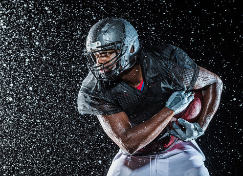 Water splashing on black football player