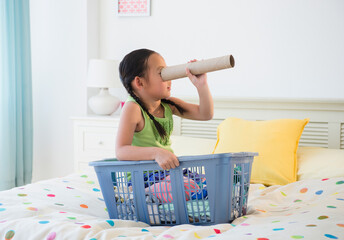 Korean girl looking through cardboard tube