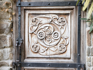 Detail of wood carved door with iron outline