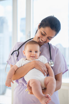 Nurse holding smiling baby
