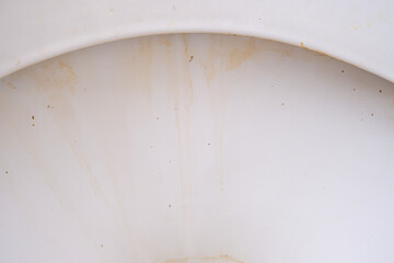 Dirty unhygienic toilet bowl with limescale stain at public restroom close up