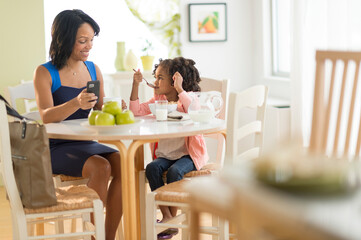 African American mother and daughter at breakfast table