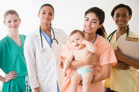 Nurses and doctor smiling with baby