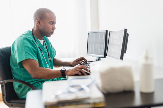 Black doctor using computer in office