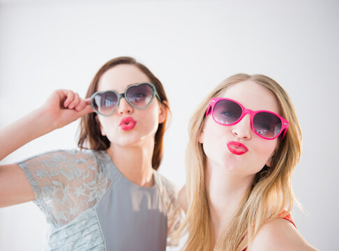 Women wearing colorful sunglasses and lipstick