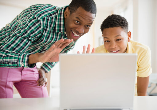 Father and son video chatting on laptop