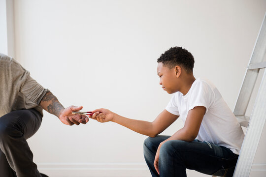Boy giving father pliers