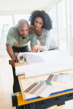 Couple examining blueprints of new home