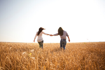 Caucasian women holding hands in rural field
