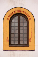 Romanesque round arched window with painted frame on the medieval Franciscan Klösterle monastery facade in the old town of Nördlingen, Germany