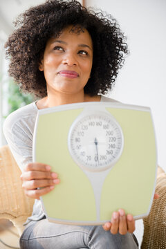 Smiling woman holding scale