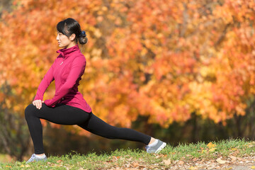 Asian runner stretching in park