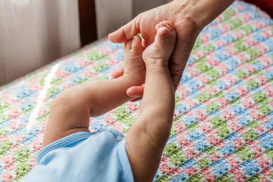 Mother holding feet of baby boy