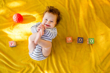 Caucasian baby girl playing with blocks on bed