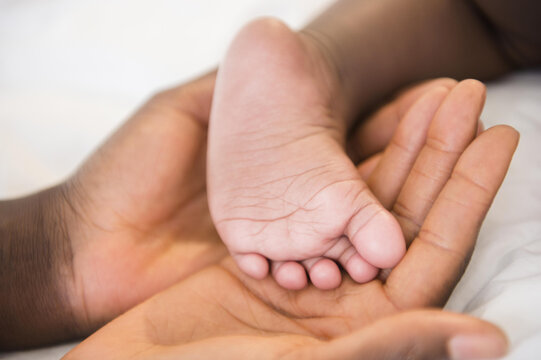 Close up of Black mother holding foot of baby