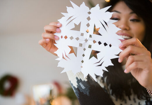 Pacific Islander Woman Holding Paper Snowflake