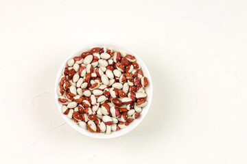 Raw spotted beans in a white bowl. Food.