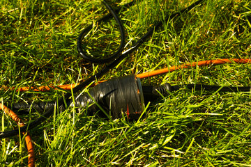 Black electric socket in the grass. Concept of using electricity in the garden.