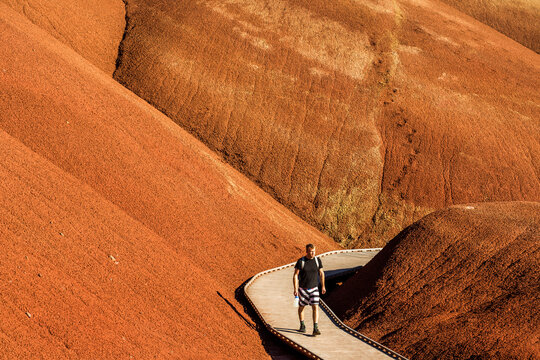 Caucasian hiker on wooden walkway in desert hills