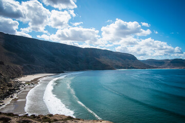 Ocean waves on beach under mountains