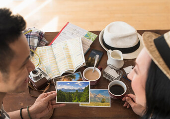 Close up of traveling couple admiring photographs at breakfast