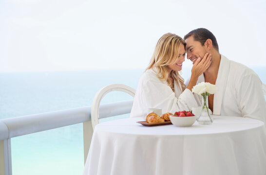 Couple eating breakfast on balcony