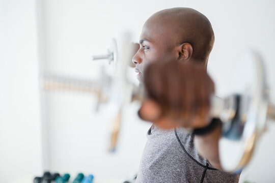 Black man lifting weights in gym